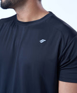 Chest and shoulder area of a black activewear tee highlighting the raglan sleeve design.