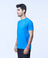 Man posing in a blue recycled polyester activewear t-shirt and joggers against a white background.