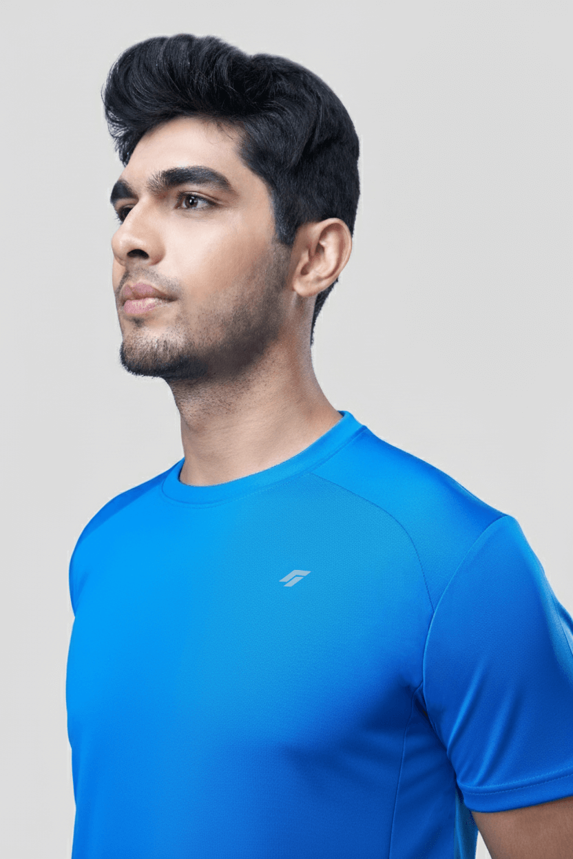 Man wearing a blue active t-shirt with a logo on a light gray background