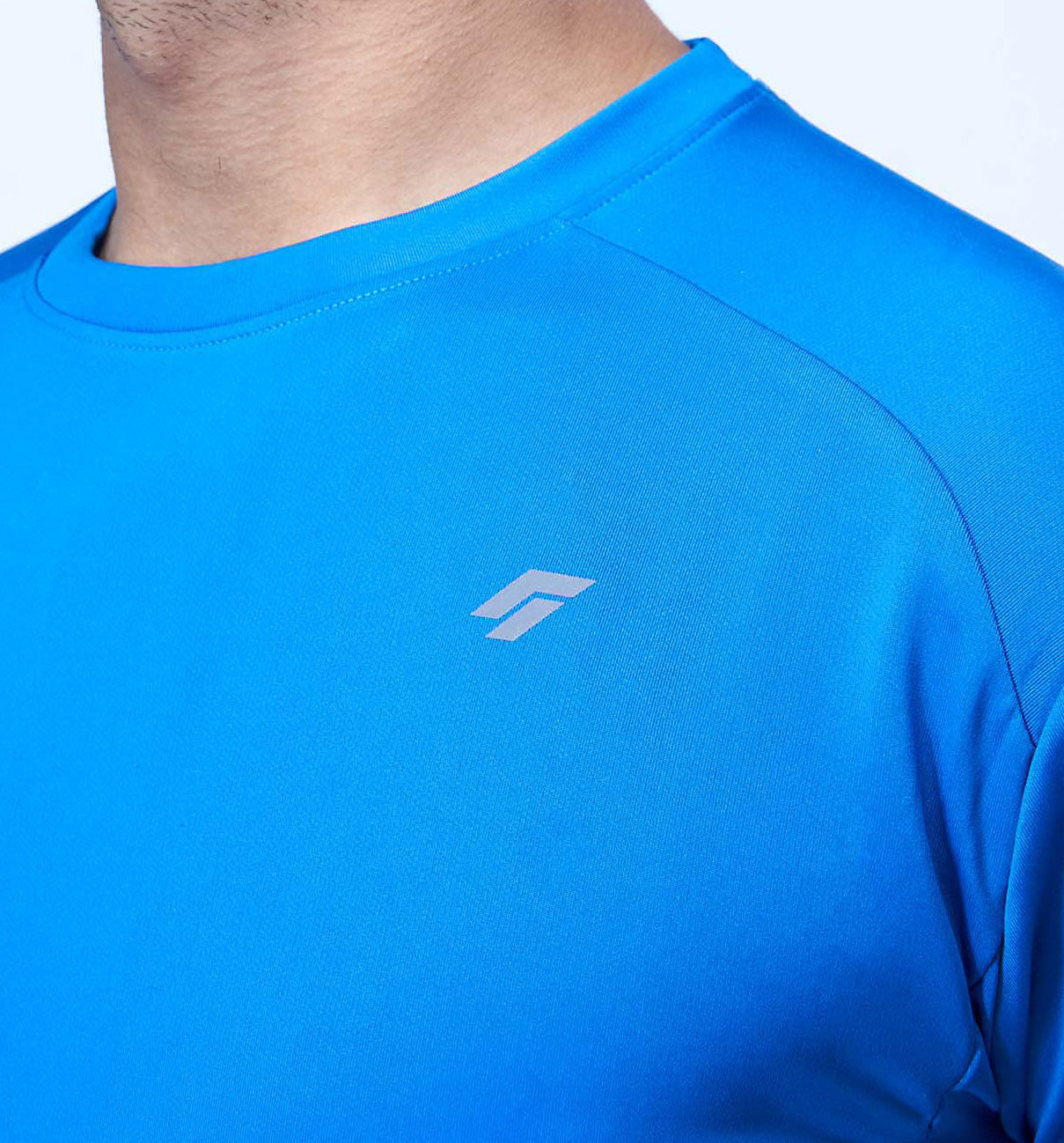 Chest and shoulder area of a man in a blue activewear tee highlighting the shoulder design.