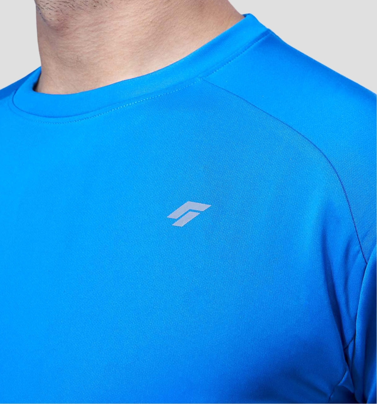 Chest and shoulder area of a man in a blue activewear tee highlighting the shoulder design.