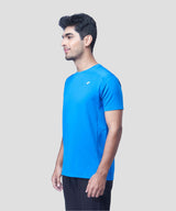 Man posing in a blue recycled polyester activewear t-shirt and joggers against a white background.