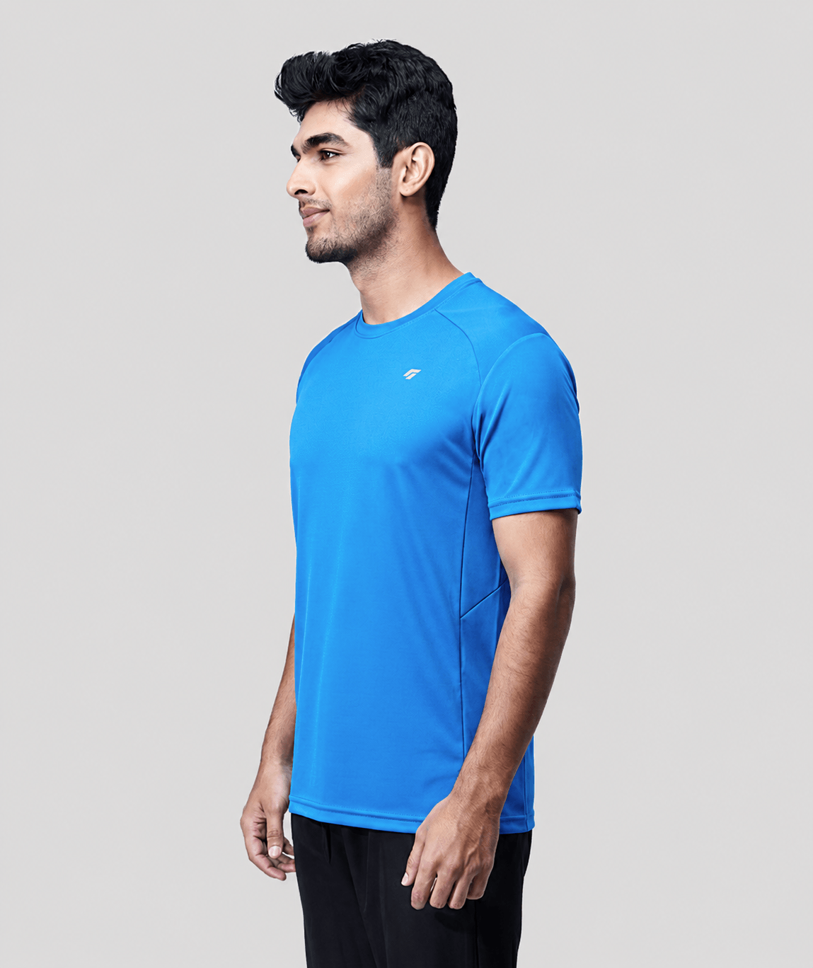 Man wearing a blue active  t-shirt on a light gray background