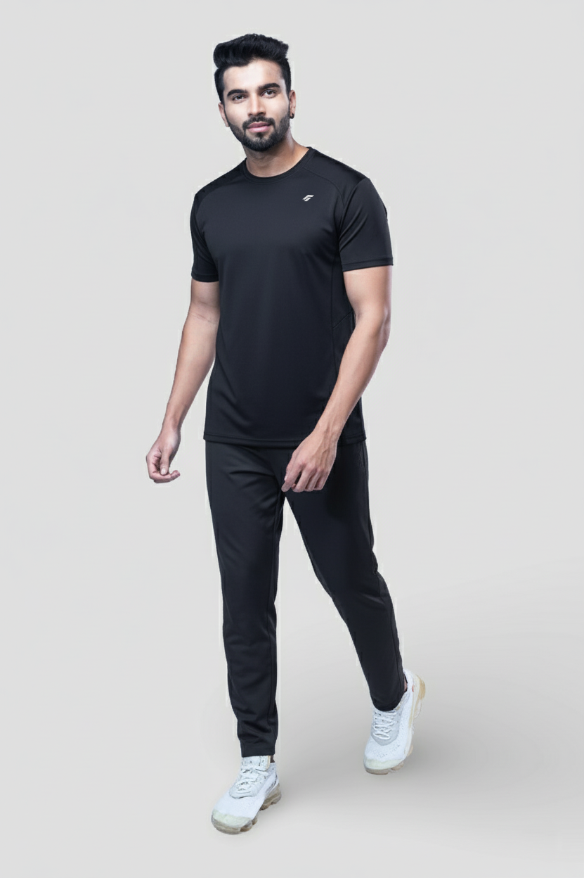 Man wearing a black active t-shirt and joggers on a light gray background