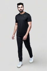 Man wearing a black active t-shirt and gray joggers against a light gray background