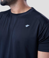 Chest and shoulder area of a man wearing black activewear tee highlighting the raglan sleeve design.