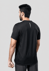 Back view of a man wearing a recycled polyester black activewear t-shirt against a gray background.
