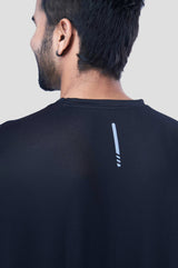 Back view of a man wearing a black recycled polyester activewear t-shirt emphasizing the material.