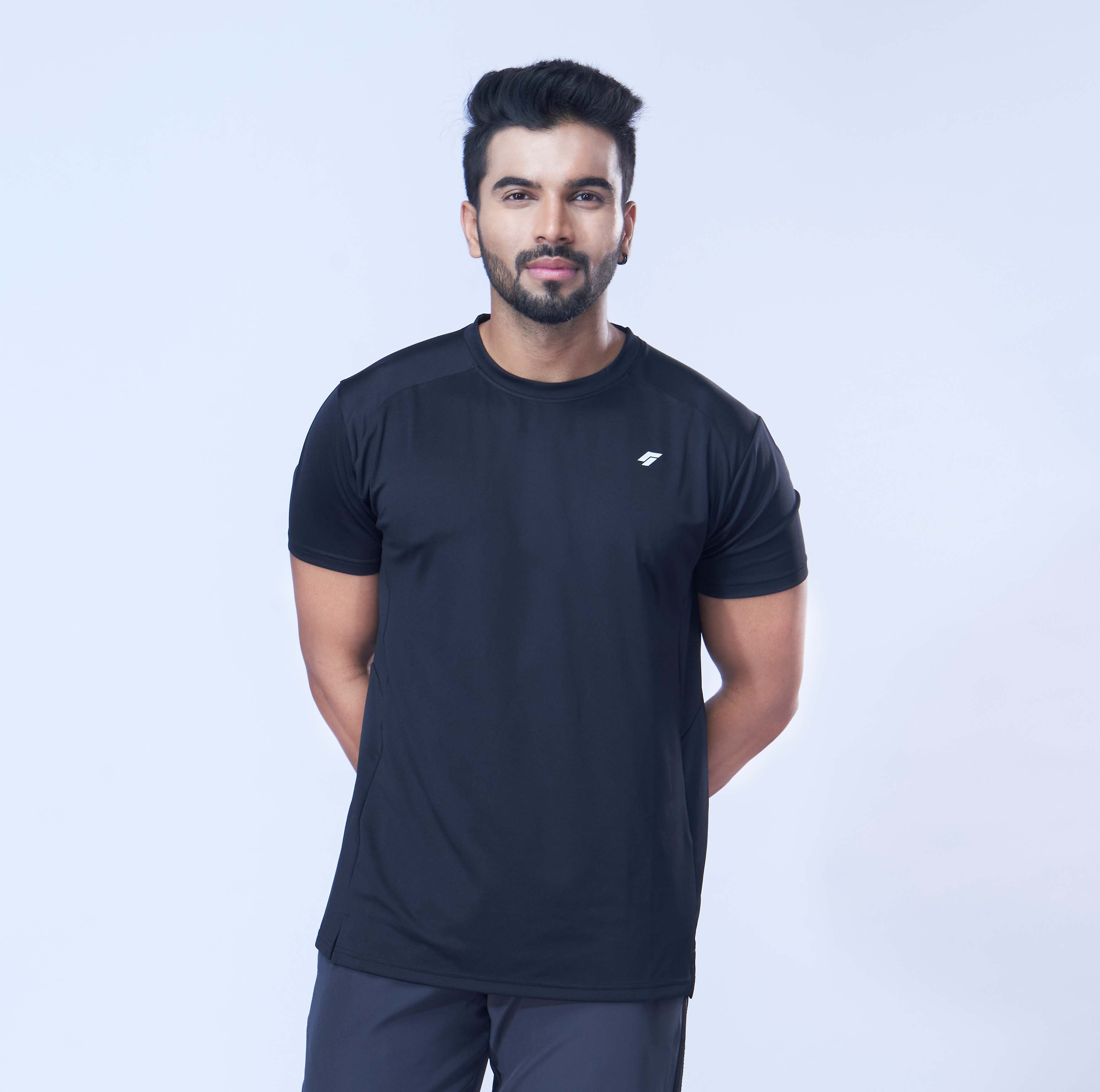 Man posing in a comfortable black recycled polyester activewear tee against a white background.