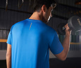 Male athlete wearing a blue activewear t-shirt seen from the back holding a dumbbell.